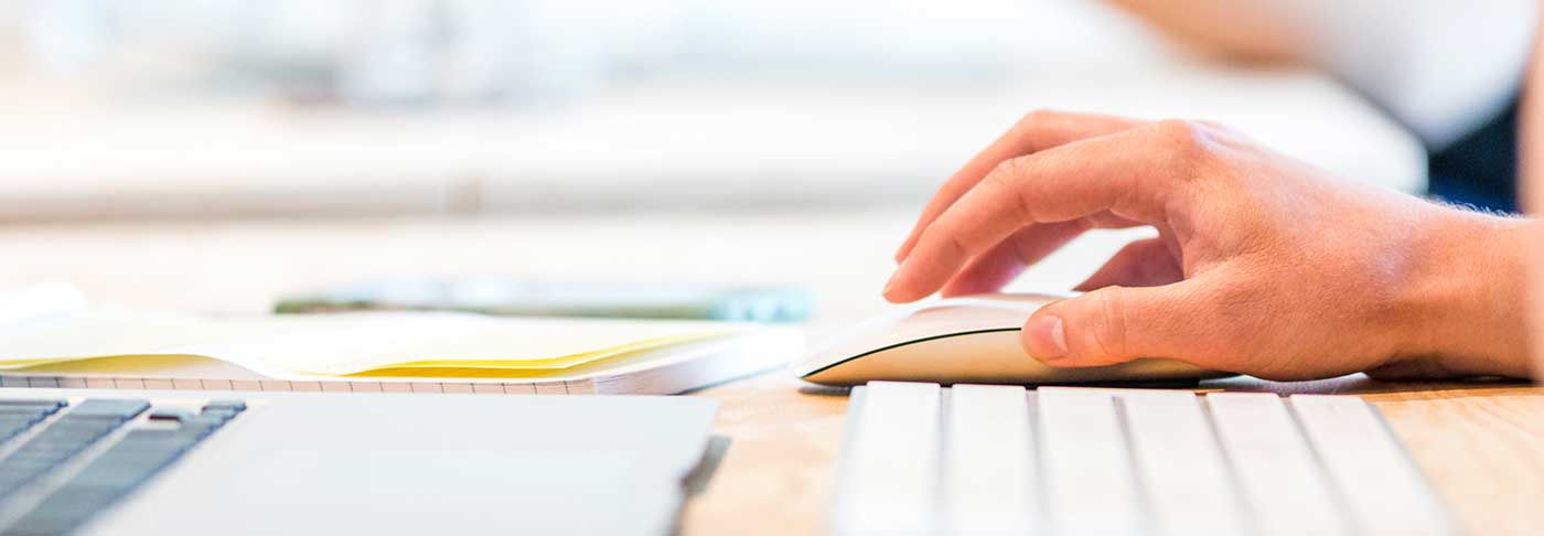 Hand on a mouse with a keyboard in the foreground
